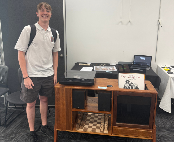 a student posing next to a coffee table with records