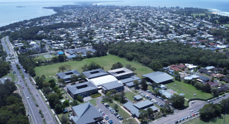 an aerial shot of the school showing all the blocks and the surrounding ocean