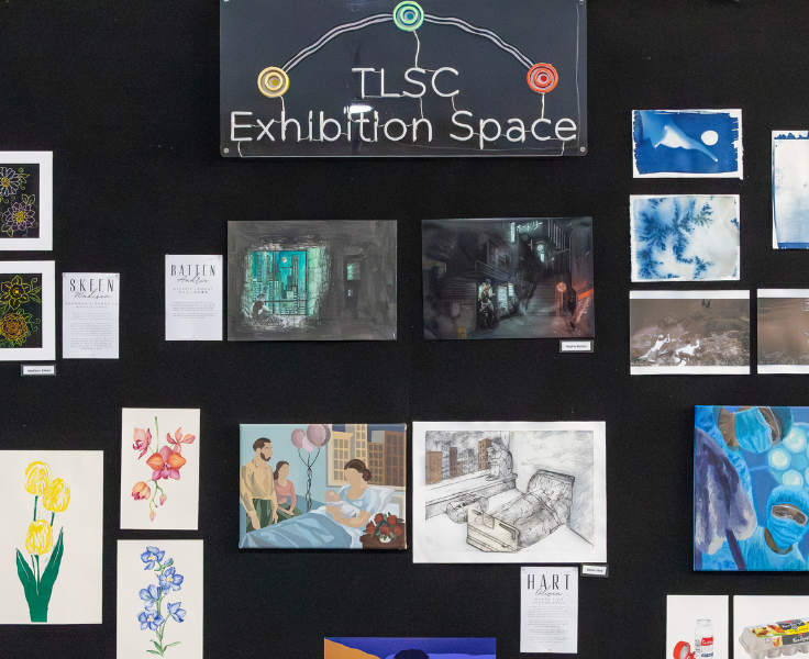 a sign which reads tlsc exhibition space with student artworks displayed underneath