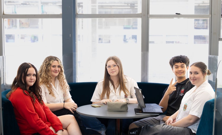 a group of students sitting at a table smiling